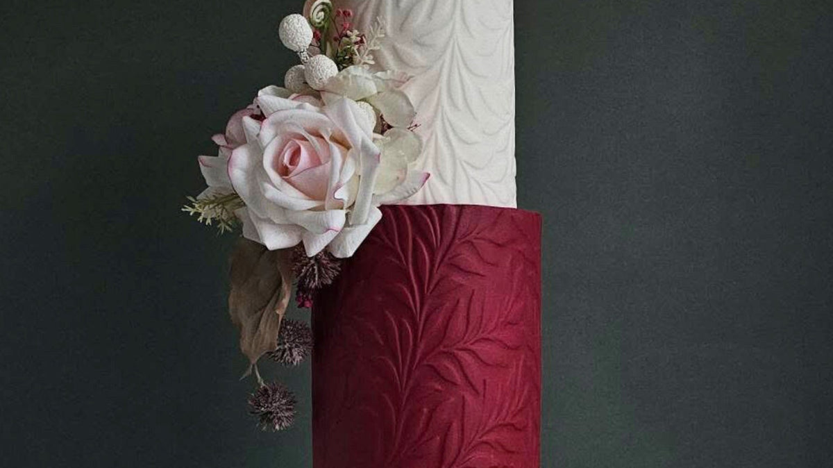 Textured wedding cake covered in a pressed Full Bloom floral pattern by Dee-vine Cakes